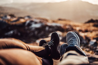 Low section of man relaxing on rock