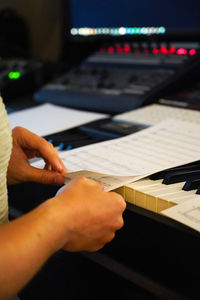 Close-up of hand playing piano