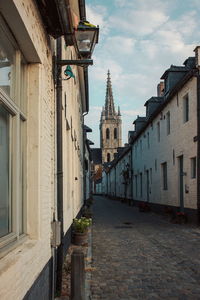 Alley amidst buildings in city against sky