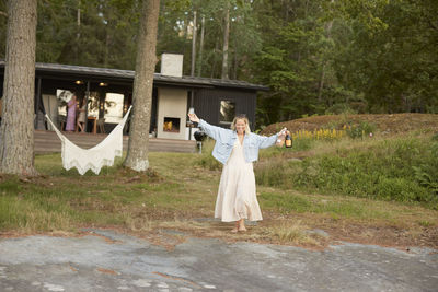 Happy woman holding wineglass and bottles