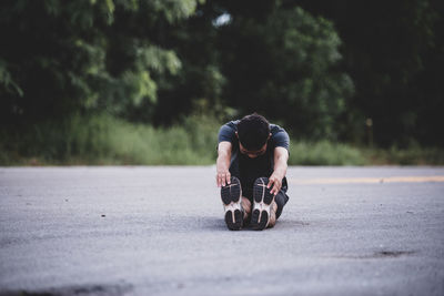 Low section of man skateboarding on street