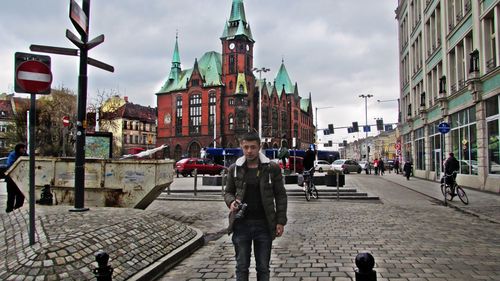 People standing on street amidst buildings in city