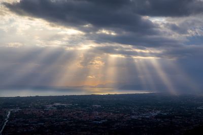 Sunlight streaming through clouds over sea