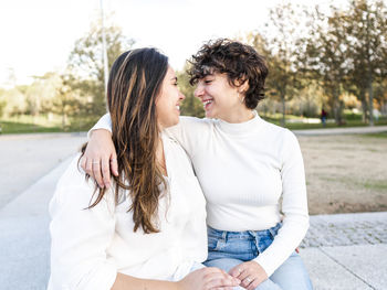 Young lesbian women with arm around looking at each other