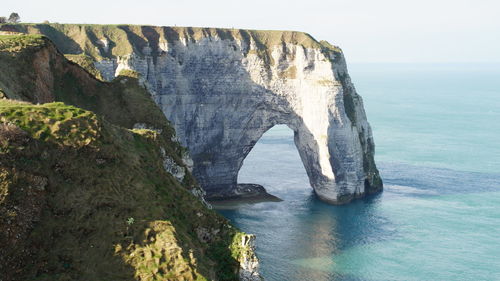 Rock formations by sea against sky