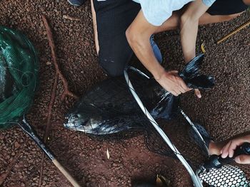 Low section of people holding fishing net 