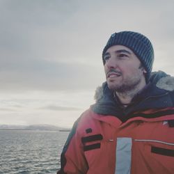 Portrait of smiling man in sea against sky