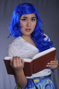 Portrait of young woman holding book