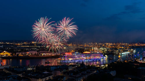 Firework display over river against sky at night