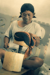 Smiling mature man holding textile at home