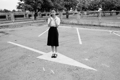 Full length portrait of girl wearing uniform standing outdoors