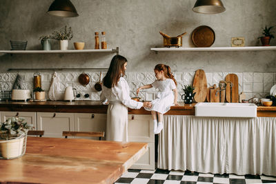 Woman standing on table at home