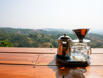 Tea cup on table against clear sky