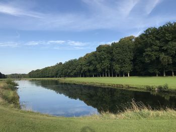 Scenic view of lake by trees against sky