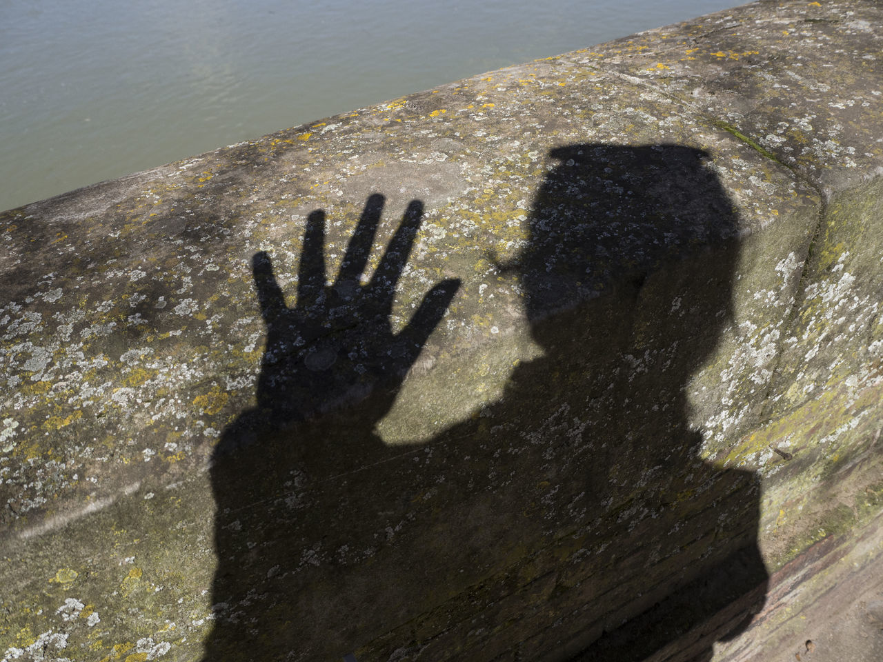 SHADOW OF PERSON HAND ON WALL