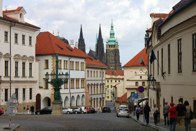 People on road amidst buildings in city