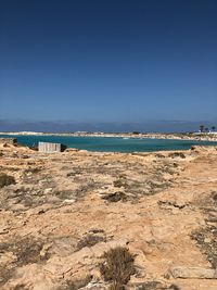 Scenic view of beach against clear blue sky