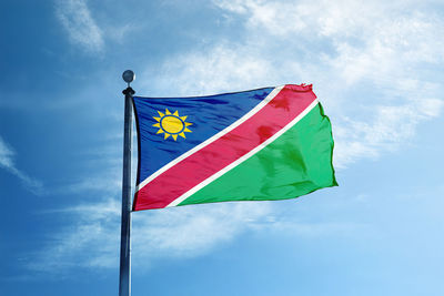 Low angle view of flag against blue sky