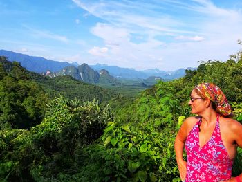 Woman looking at mountains against sky