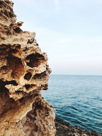 Close-up of rocks on shore against sky