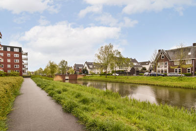 Houses by lake against sky