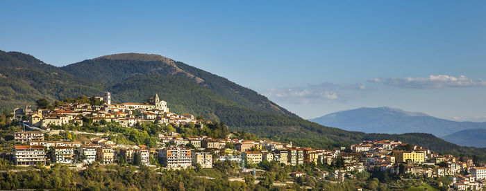 Townscape by mountains against sky