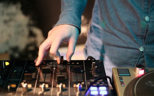 Midsection of dj playing music