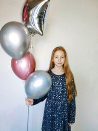 Portrait of a smiling girl holding balloons