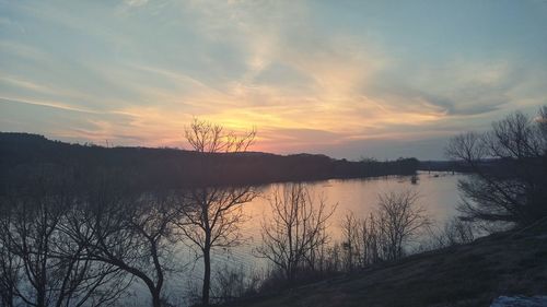 Scenic view of lake against sky at sunset