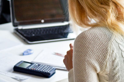 Rear view of woman using laptop