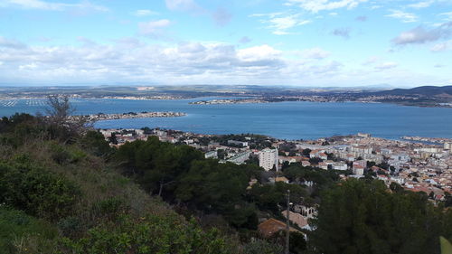 High angle view of townscape by sea against sky