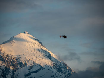 Low angle view of airplane helicopter  flying in sky mountain
