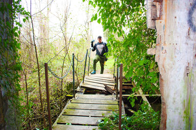 People standing on footbridge in forest