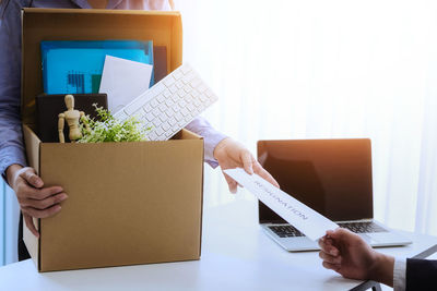 Midsection of man working with book on table