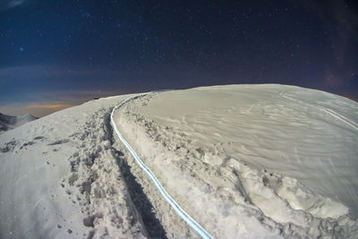 Scenic view of snowcapped mountains against sky at night