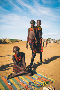 Full length portrait of happy friends on land