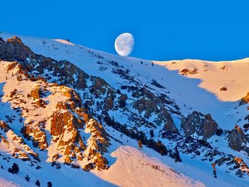 Scenic view of snowcapped mountains against clear blue sky