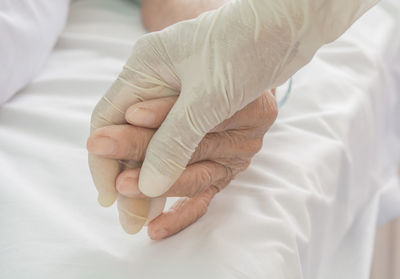 Close-up of hands on bed
