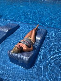 High angle view of woman lying at swimming pool