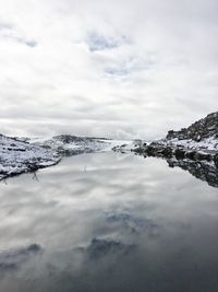 Scenic view of sea and snowcapped mountains against sky