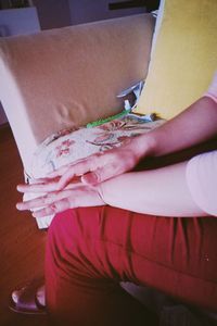 Midsection of woman sitting on chair at home