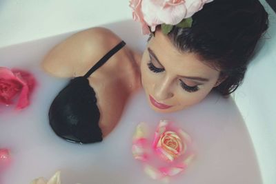 High angle view of sensual woman resting in bathtub while taking milkbath