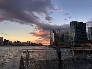 Silhouette of buildings in city at sunset