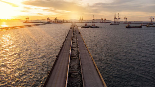 Pier on sea against sky during sunset