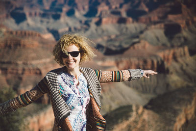 Portrait of young woman wearing sunglasses standing outdoors