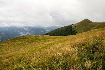 Scenic view of mountains against cloudy sky