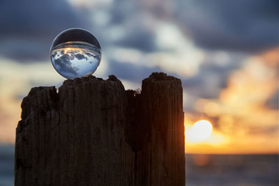 Close-up of wooden post in sea against sky