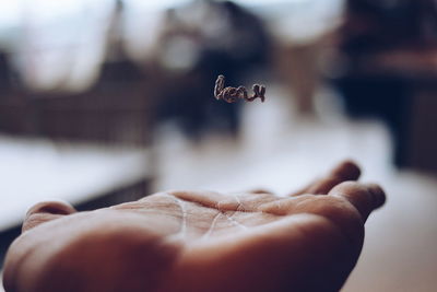 Close-up of hand holding object over white background