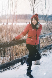 Full length portrait of young woman in snow