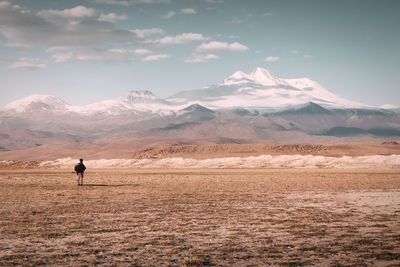 Man standing on desert against mountains